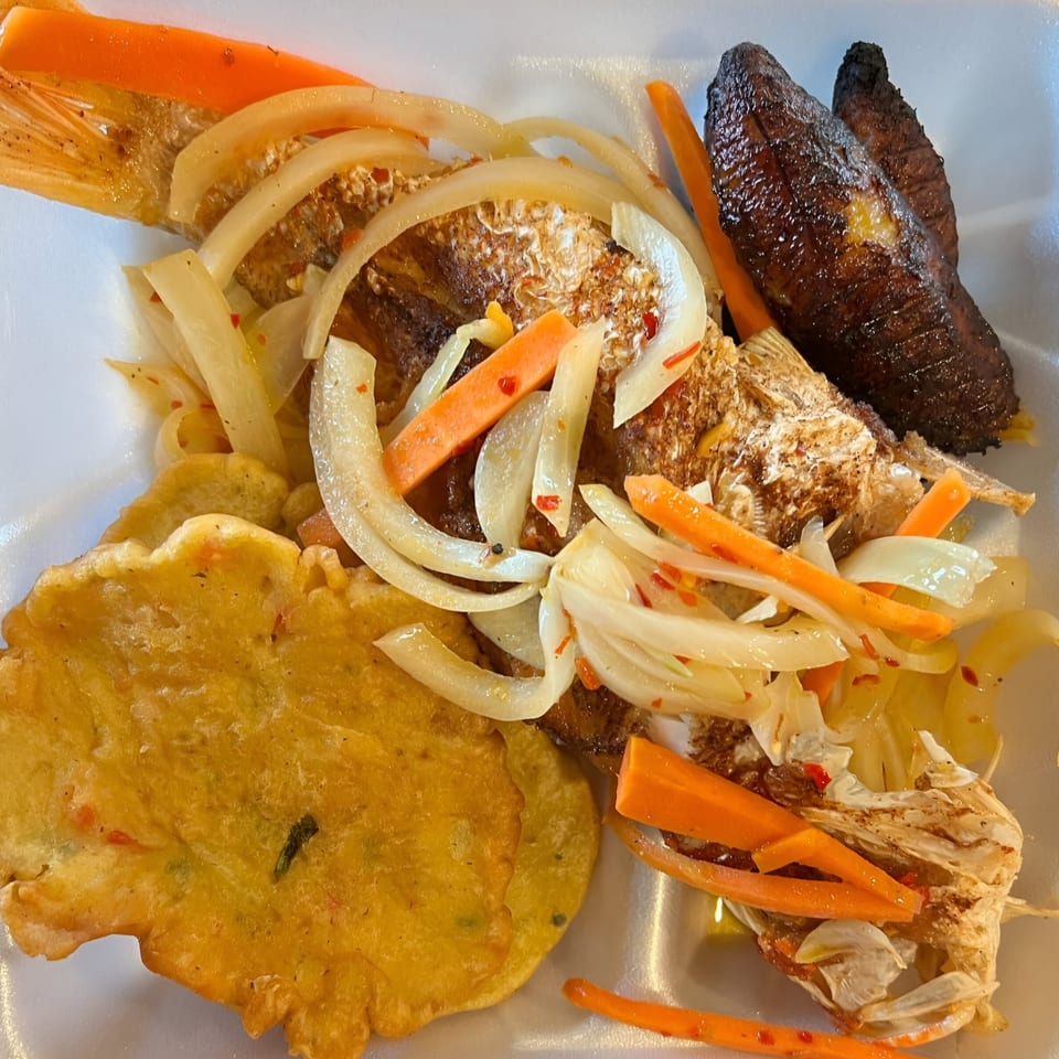 Jamaican escovitch fish with pickled onions and carrots, fried plantains, and a festival dumpling.